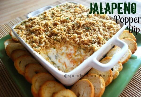 Jalapeno Popper Dip with cream cheese, spicy diced jalapenos and sharp cheddar topped with crispy Panko bread crumbs on top in a white dish with crostini on the side