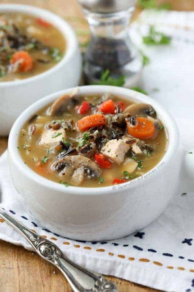 Chicken Wild Rice Soup with carrots and mushrooms with pepper and parsley on a table