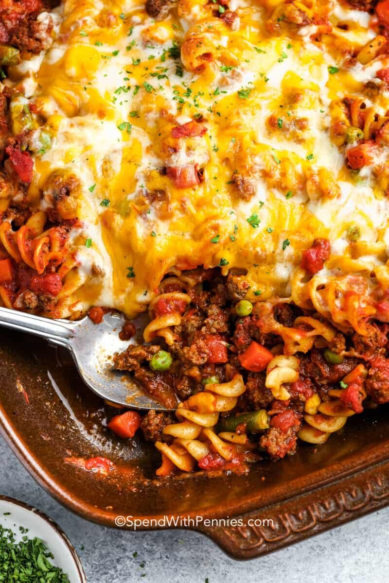 a casserole dish of baked hamburger casserole with a spoon