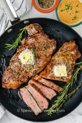 steak in a pan sliced to show How to Cook Juicy Steaks in the Oven