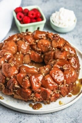 cooked Monkey Bread with raspberries and whipped cream in the background