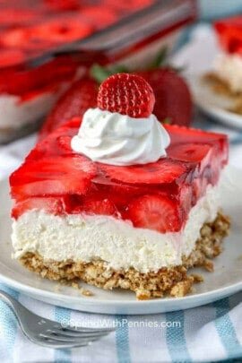 Strawberry Pretzel Salad on a plate with whipped cream and strawberry as garnish