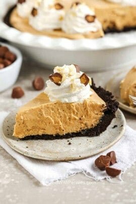 slices of Peanut Butter Pie on a plate with full pie in the back